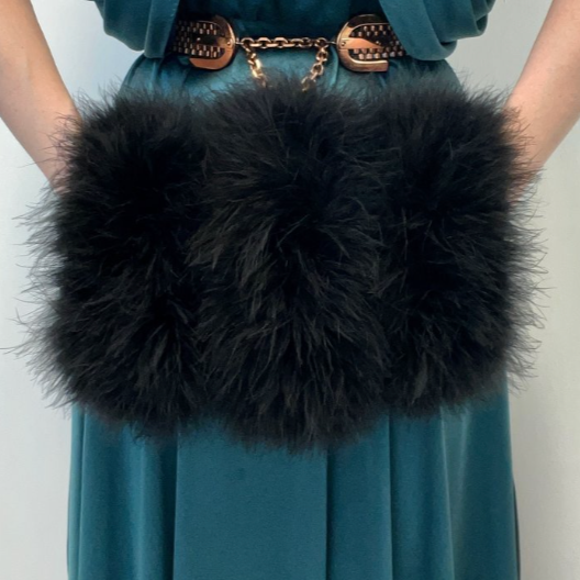 A woman's hands in a black marabou muff