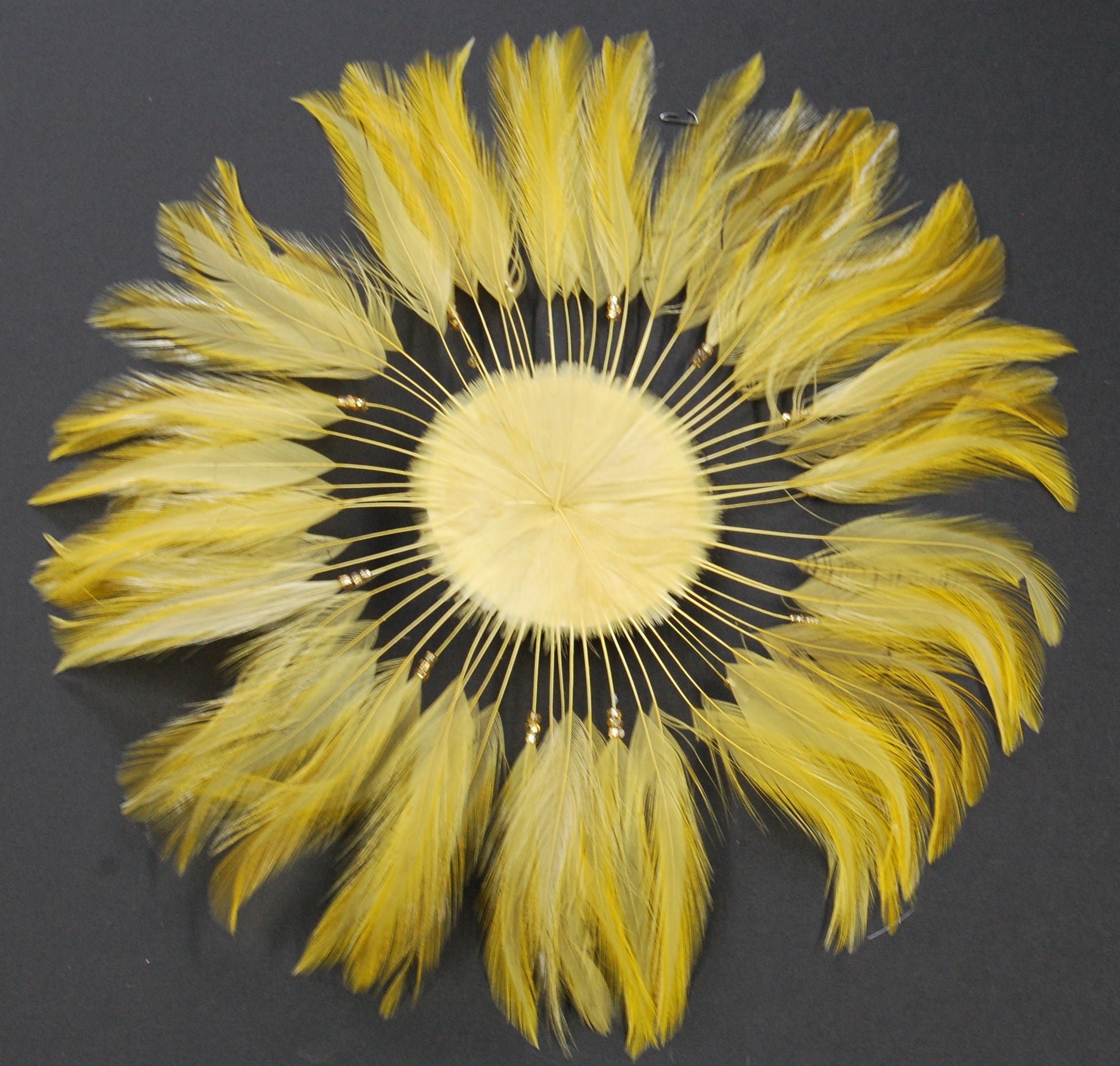 A dark gold feather pinwheel great for costumes