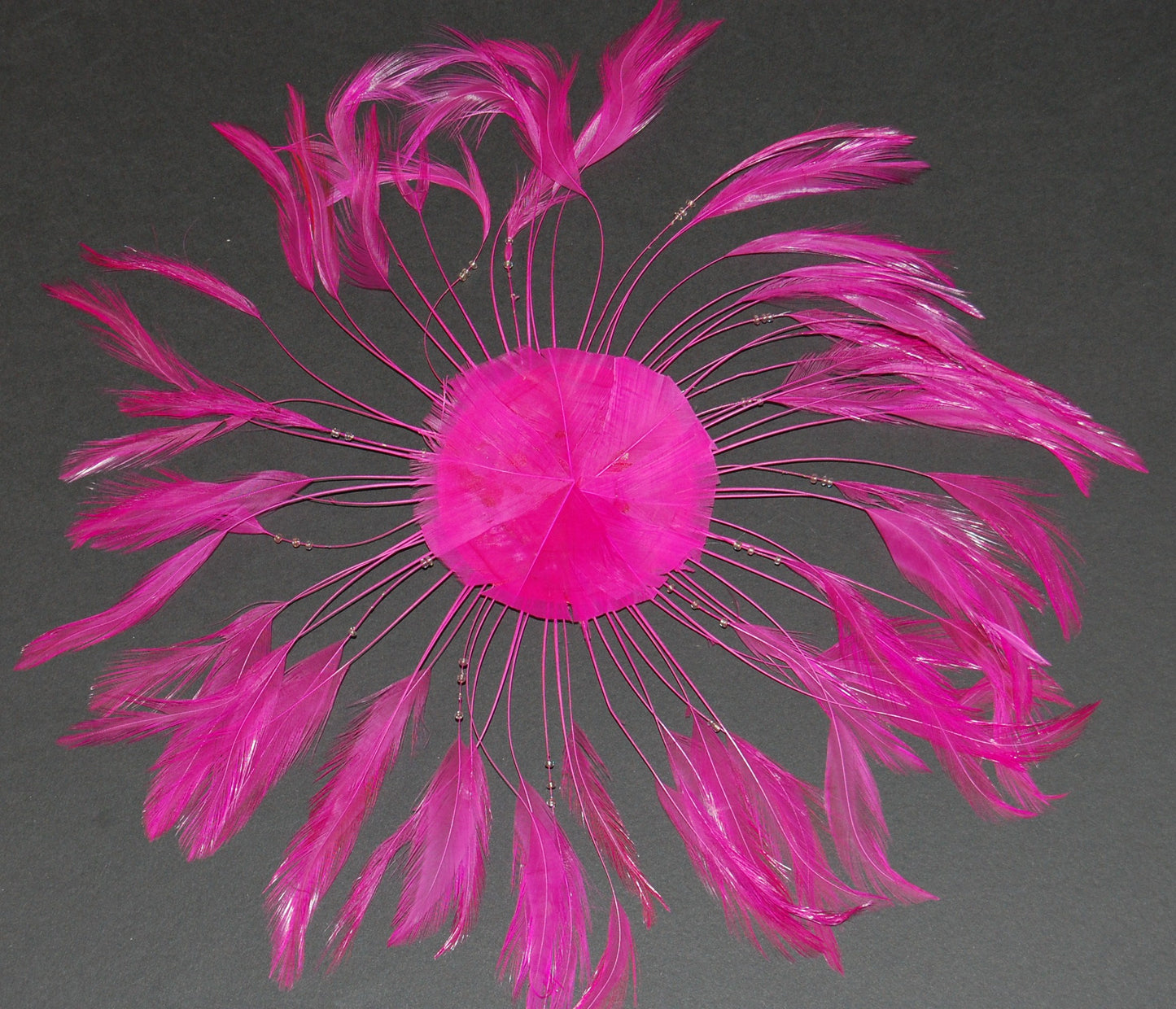 A fuchsia colored pinwheel on a grey background