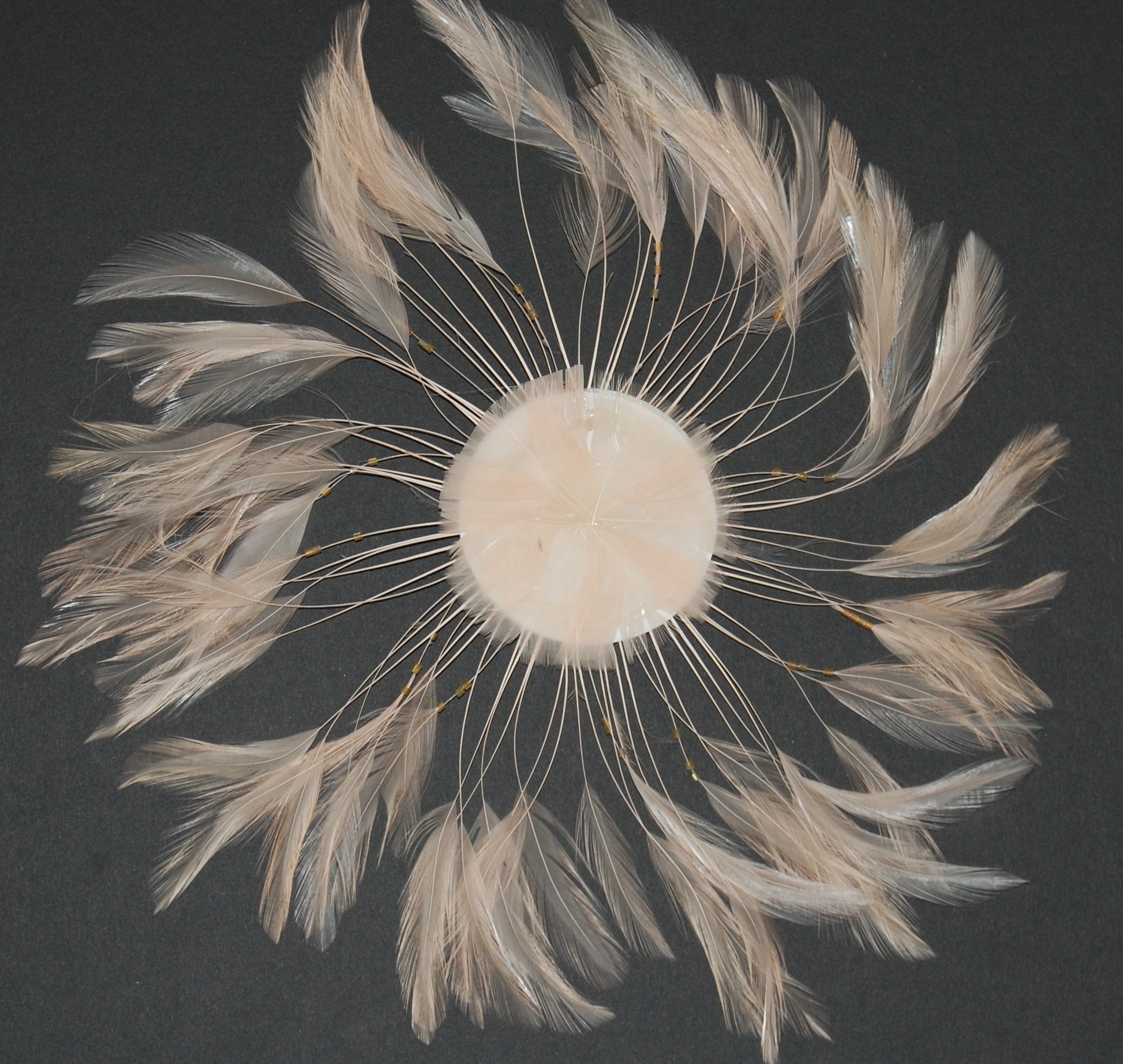 a beige colored feather pinwheel